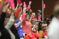 An RA delegate holds her card high during a floor vote.